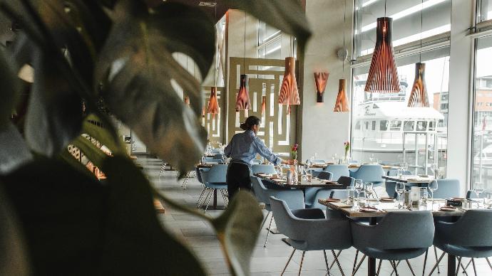 woman in front on brown dining table and chairs inside building